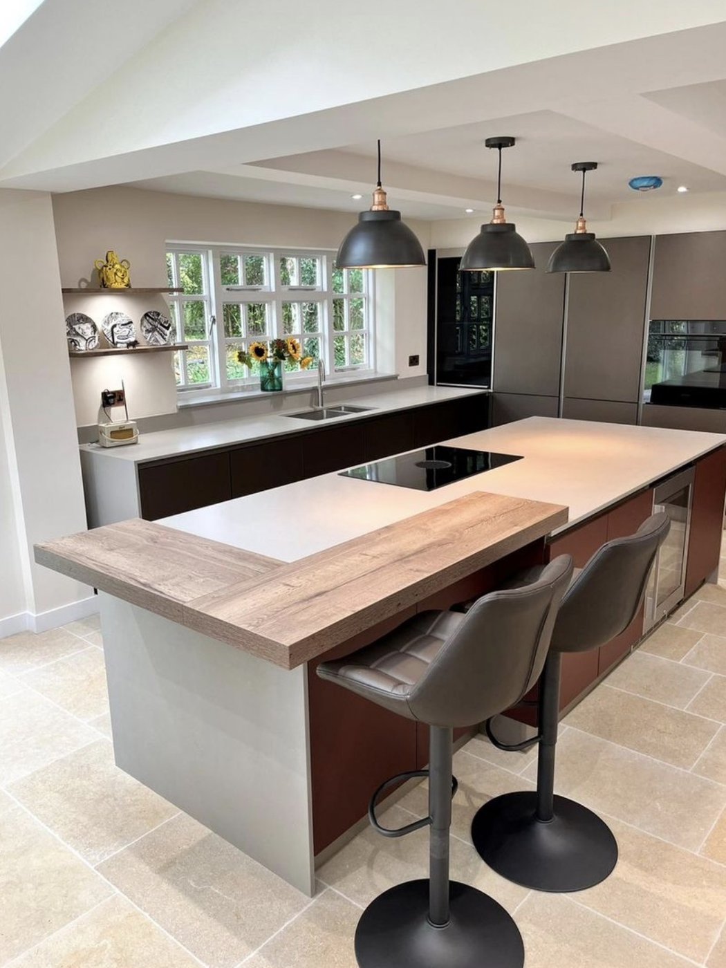 Cotswold cottage kitchen with three black pendants over a long island