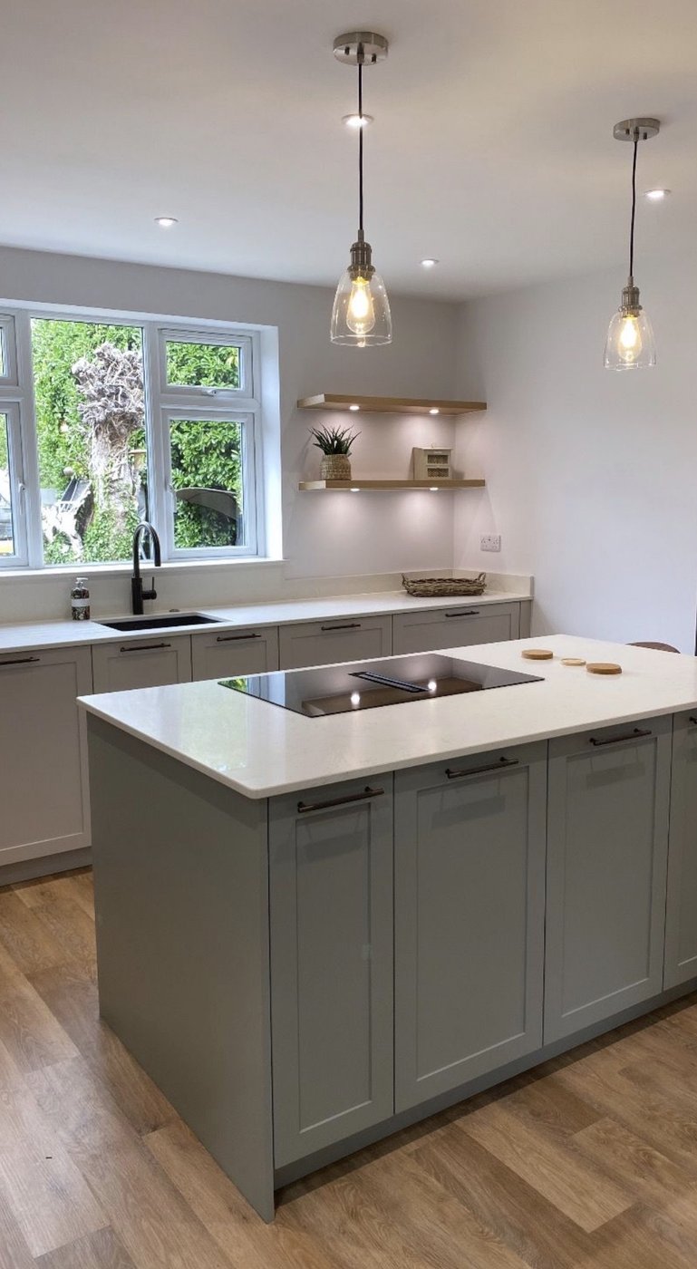 Sage shaker kitchen with glass bell pendants and inset shelf lighting