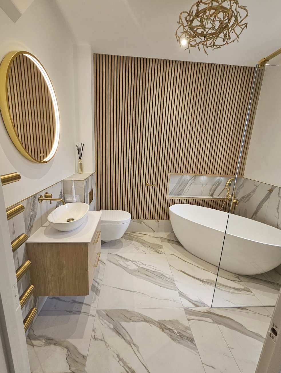 Luxury marble bathroom with brass fixtures and slatted wood feature wall